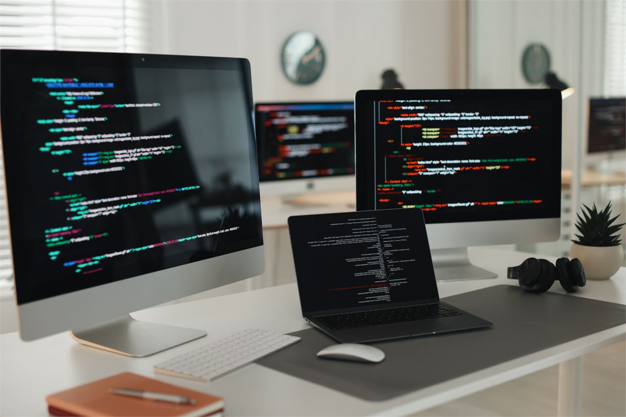 Mehrere Monitore zeigen den HTML- und CSS-Code einer Website